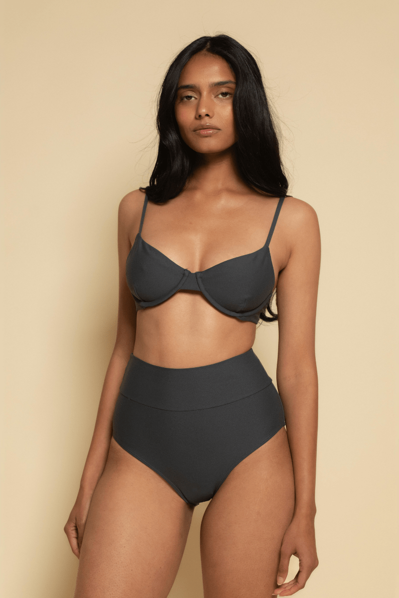 Charcoal bikini top with thin shoulder straps and underwire cups on a model with high-waisted black bikini bottoms.