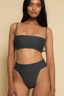 Charcoal bikini top with thin shoulder straps and straight neckline on model.