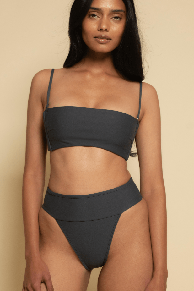 Charcoal bikini top with thin shoulder straps and straight neckline on model.