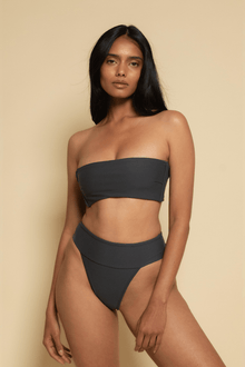 Black strapless bandeau bikini top on model against neutral background.