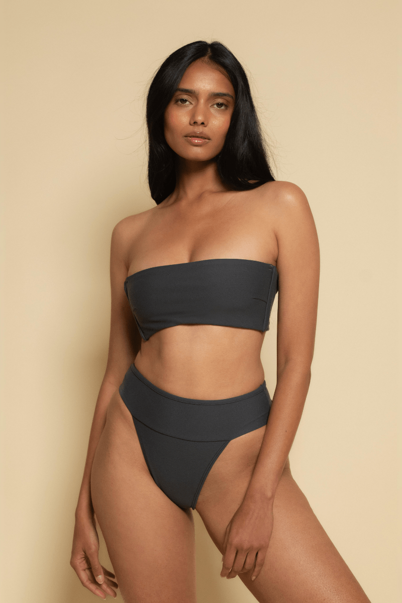 Black strapless bandeau bikini top on model against neutral background.