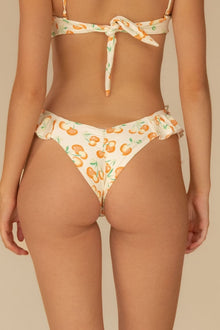 Cream bikini bottom with orange cherry print and ruffled edges at leg openings and waistband.