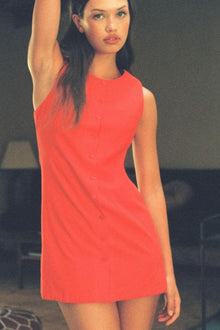 Red sleeveless button-down tank dress with crew neckline on model.
