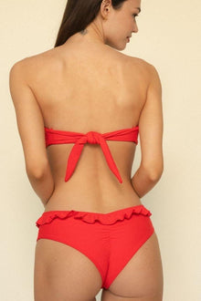 Red bikini bottom with ruffled waistband trim, shown from back view on model.