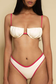 Cream and hot pink bikini bottom with bound edges and ruched sides.