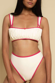 Cream bikini bottom with raspberry pink binding along the sides and waistband.