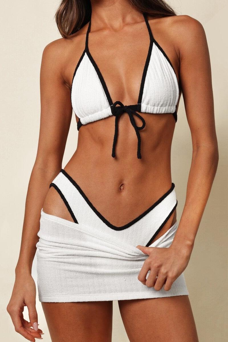 Cream and black ribbed micro skirt with textured terry fabric and high-cut sides on model.