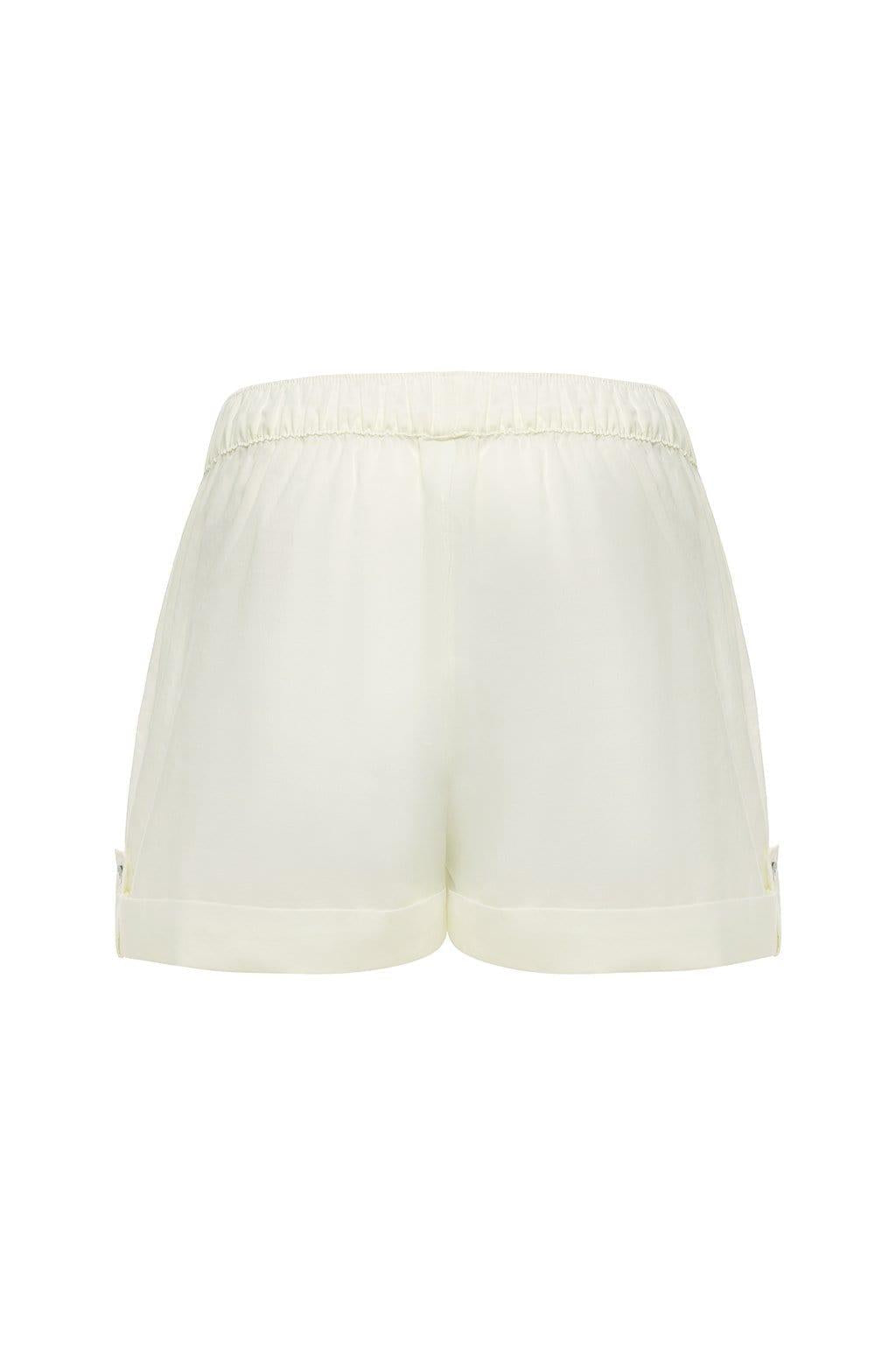 Cream lounge short with elastic waistband and folded cuffs, displayed flat against white background.