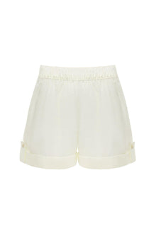 Cream-colored lounge short with elastic waistband and cuffed legs featuring side button details.