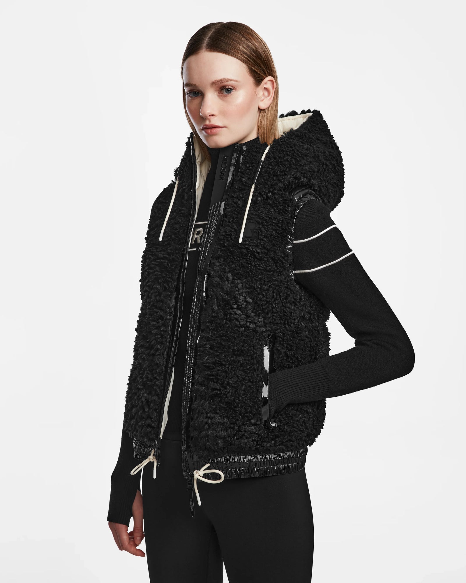 A woman in the RAQUEL S - 8124526 Black ski vest by Rudsak, ready for winter mountain adventures.