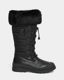 The WINDY - L224507 Black by Rudsak is a tall women's winter boot with cold-weather comfort, faux fur trim, lace-up front, quilted shaft, signature R patch on the side, and a sturdy rubber sole.