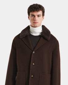 A man with short curly hair models the Rudsak AIDEN - 6125558 Espresso wool-blend coat, featuring a wide removable shearling collar, layered over a white turtleneck against a plain white background.