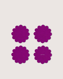 Four purple floral coasters by Graf Lantz, crafted from Merino wool, are arranged in a square on a light background. One displays the Graf Lantz brand in small white letters, offering stylish protection for your table.