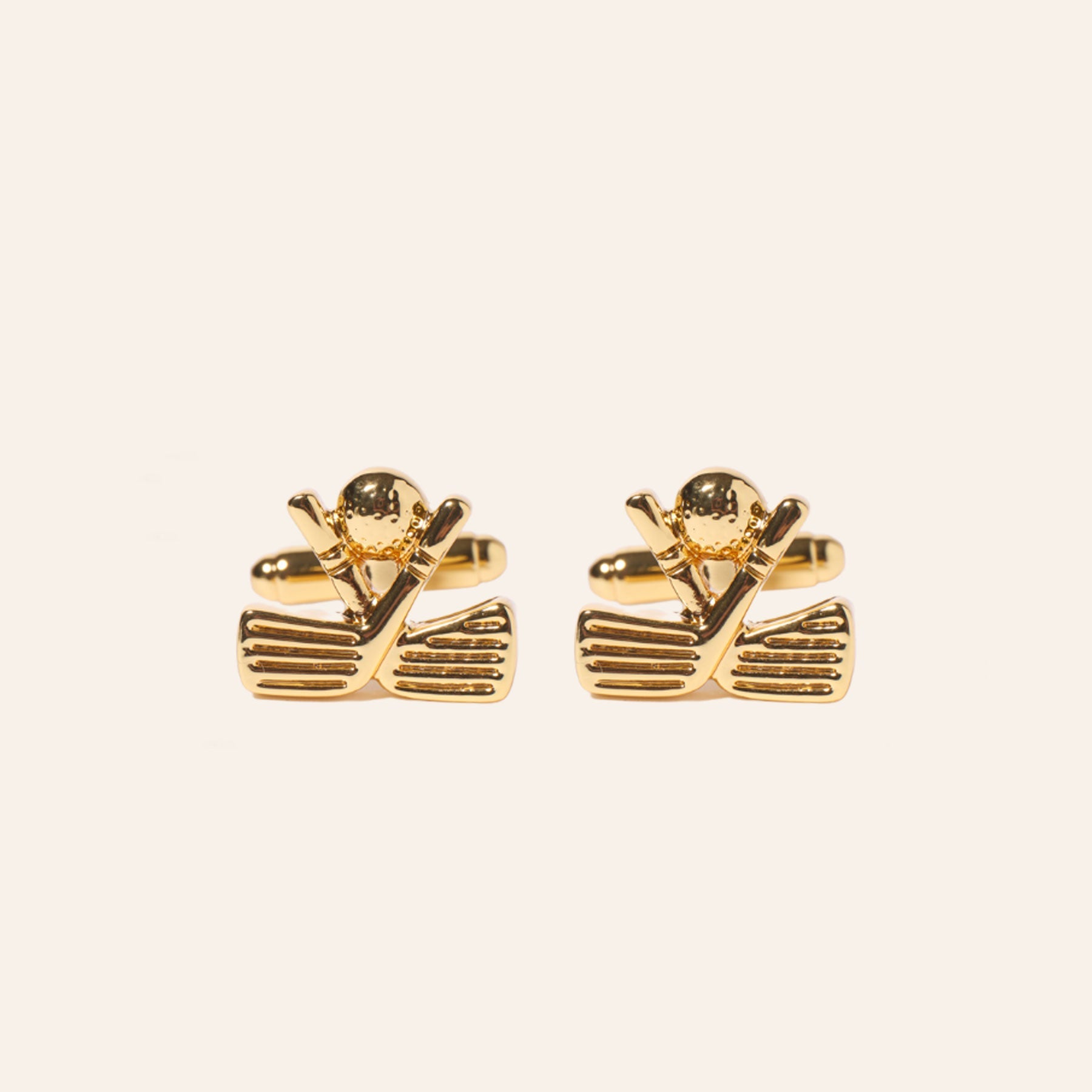 Gold Crossed Golf Clubs and Ball Cuff Links on Tan Background