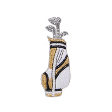 Gold, White, Black, and Silver Beaded Golf Bag Brooch on Flat White Background