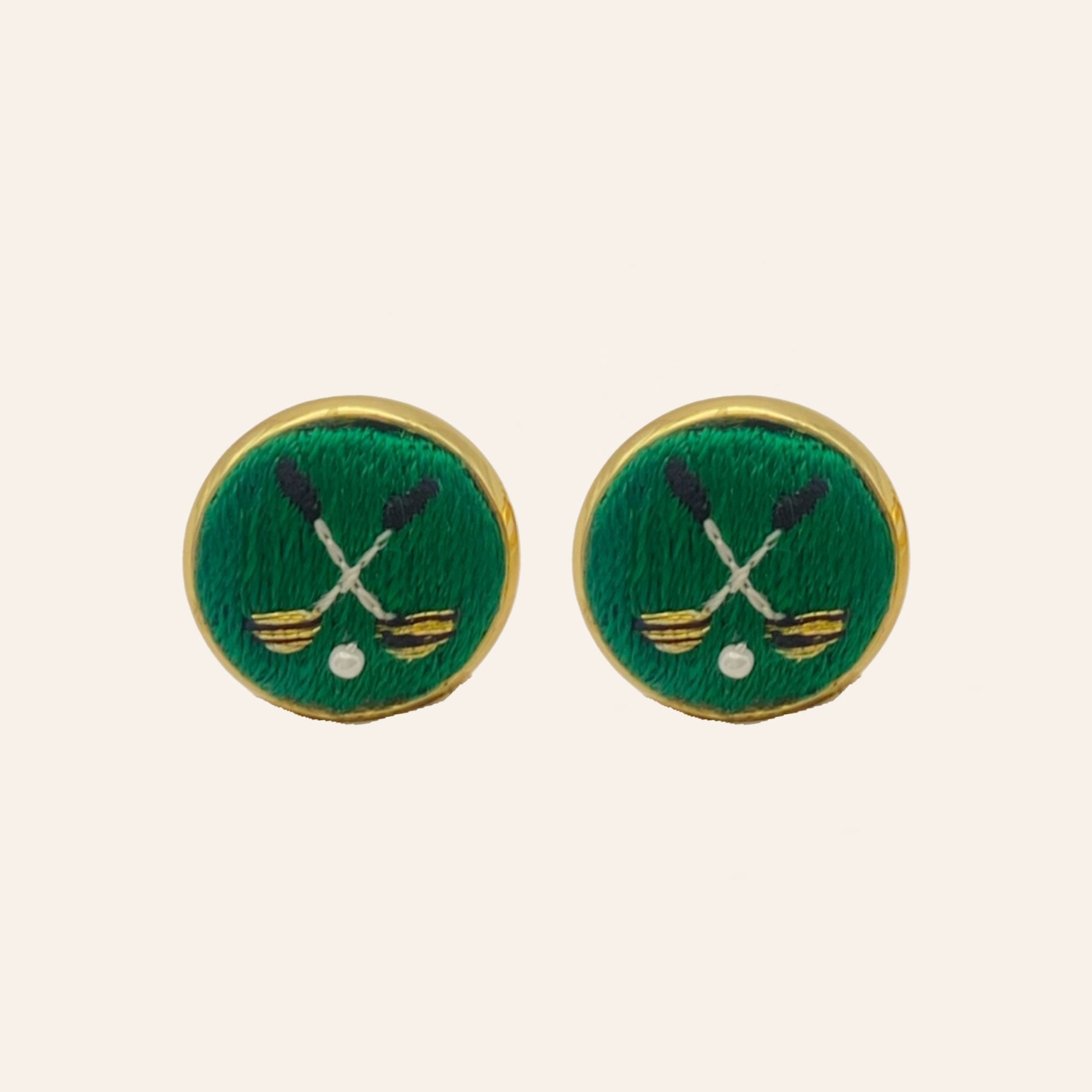 Green golf ball and club embroidered cuff links on tan background