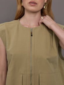 Model wears a wide shoulder, khaki zip up vest with tactical symmetrical front cargo pockets at the waist.