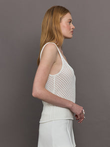 Model wears a white knit wide neck mesh patterned tank.