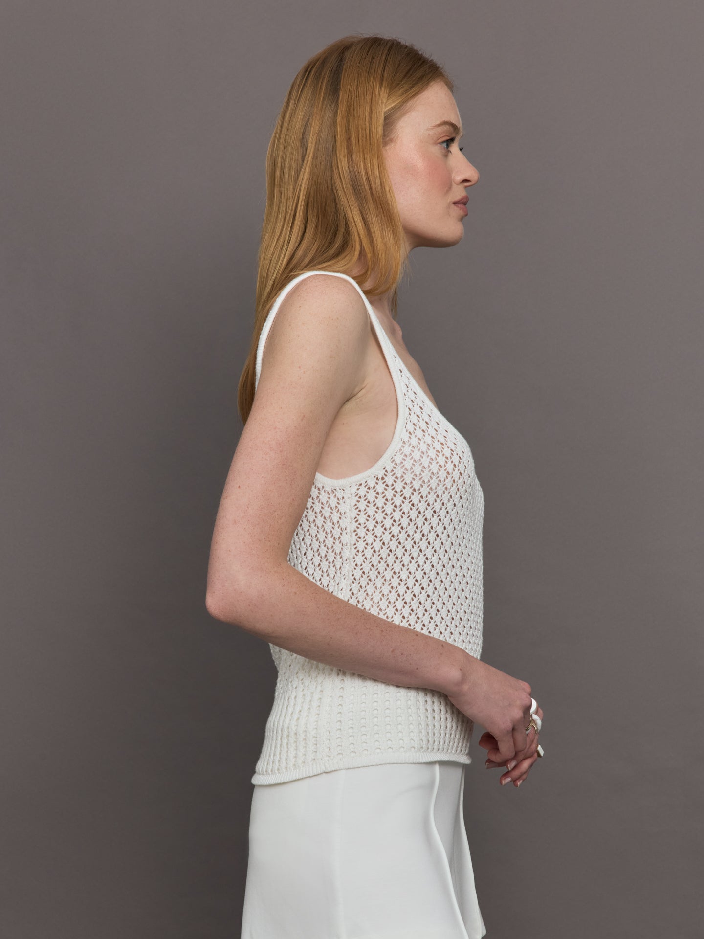 Model wears a white knit wide neck mesh patterned tank.