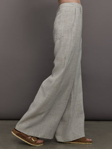 Model wears a pair of gray/taupe oversized wide leg woven work trousers.