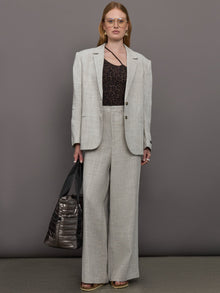 Model wears a pair of gray/taupe oversized wide leg woven work trousers.