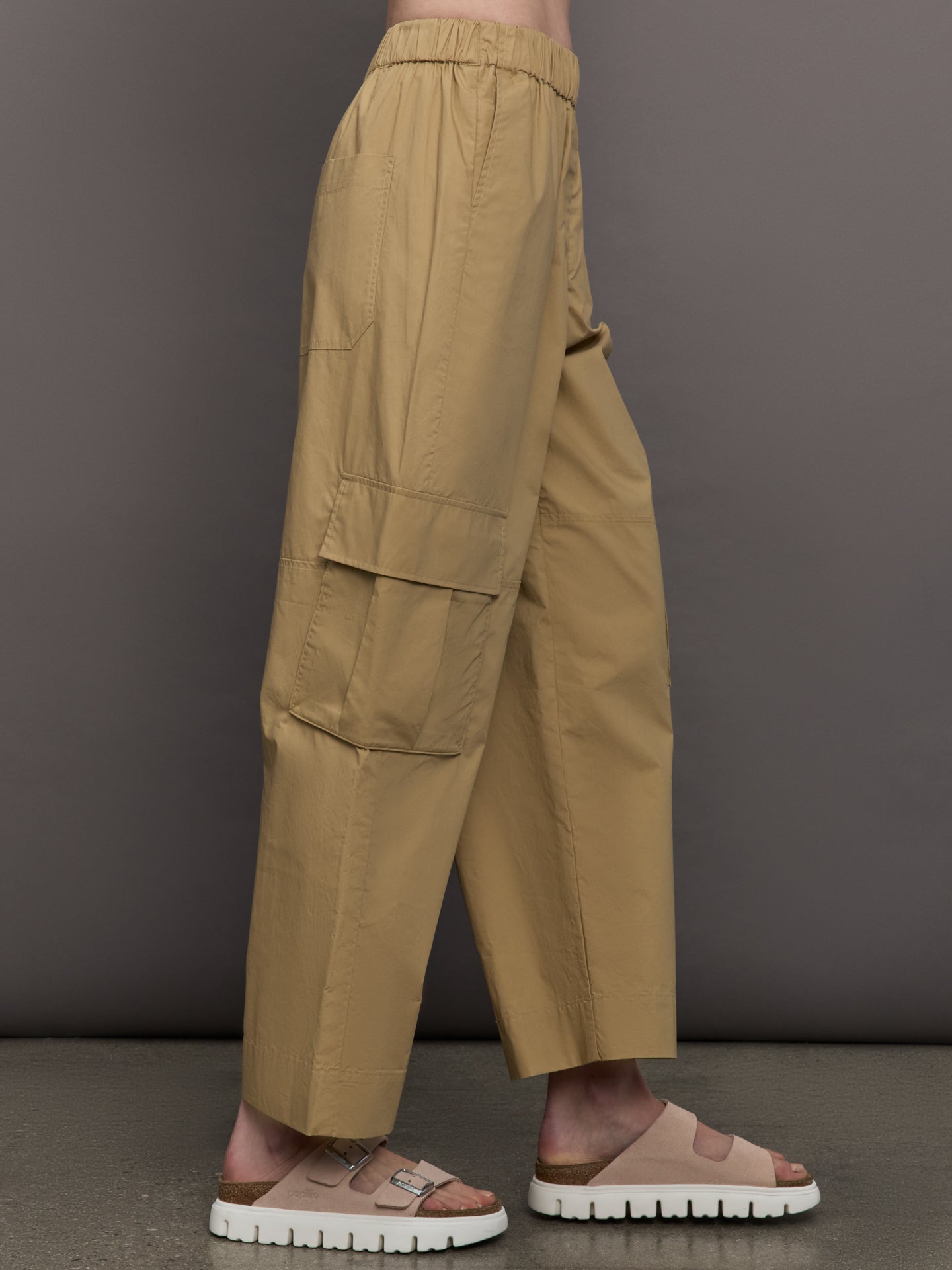 Model wears a pair of mid rise khaki cargo wide leg pants.