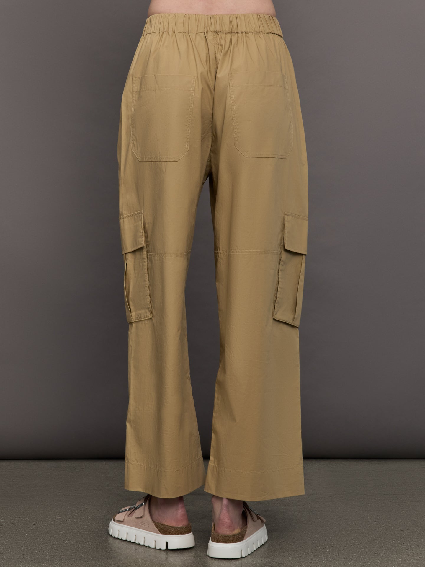 Model wears a pair of mid rise khaki cargo wide leg pants.