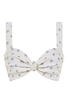 White bikini top with small blue and yellow floral print and bow-tie center detail with adjustable shoulder straps.
