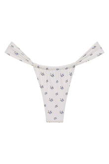 White bikini bottom with small blue and yellow floral print throughout and ruched side ties.