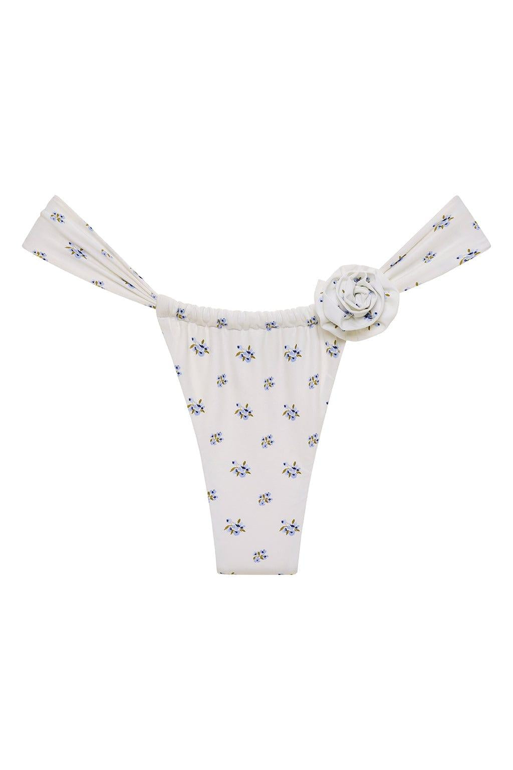 White bikini bottom with small blue and yellow floral print and decorative rosette detail at center waistband.