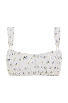 White bikini top with small blue and yellow floral print, ruched front, and adjustable shoulder straps.