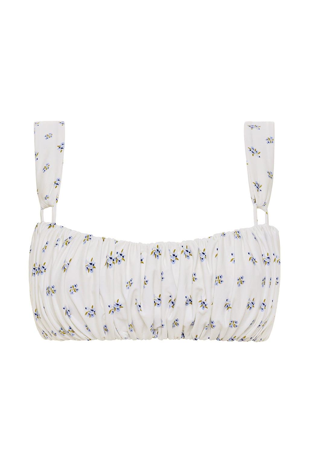 White bikini top with small blue and yellow floral print, ruched front, and adjustable shoulder straps.