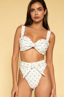 White bikini top with small blue floral print, sweetheart neckline, and bow detail at center front.