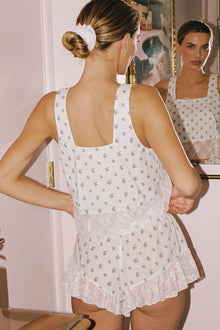 White sleeveless crop top with small floral print and square neckline, shown from back view.