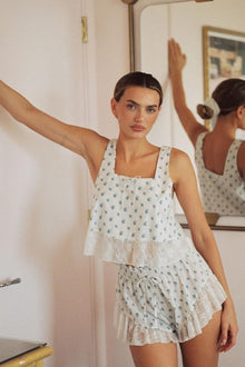 Cream crop top with small blue floral print, square neckline, and white lace trim at hem.
