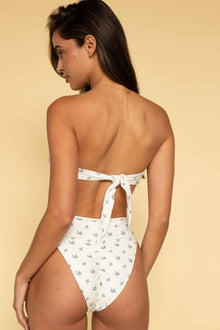 White bandeau bikini top with small blue floral print and tie-back closure, shown from behind.