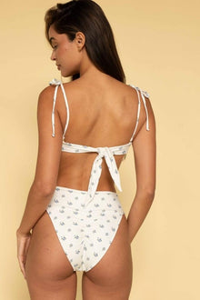 White bandeau bikini top with small floral print and tie straps, shown from back view on model.