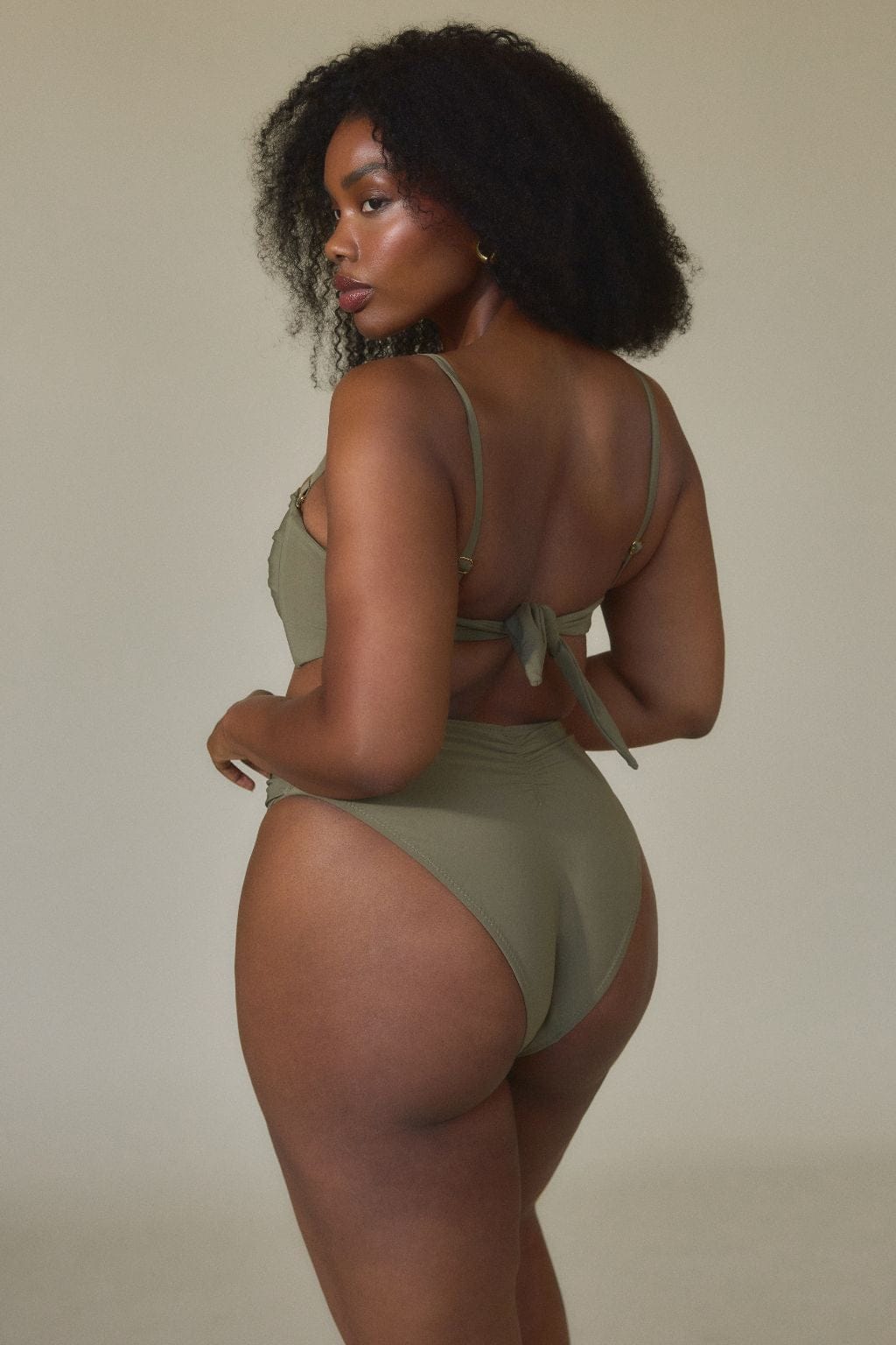 Khaki bandeau bikini top with tie back closure, shown from rear view on model.