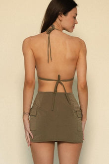 Khaki cargo skirt with side patch pockets, shown from back on model.