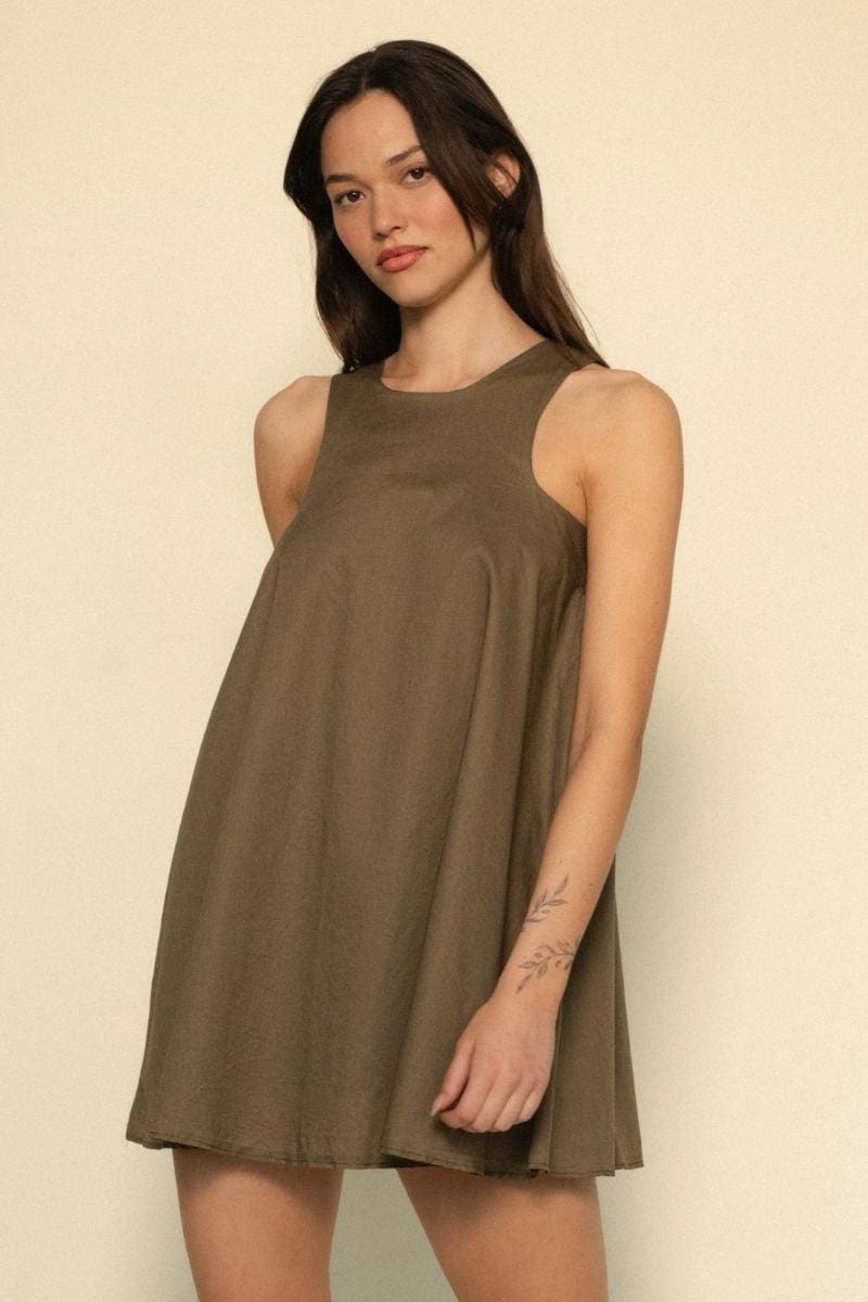 Khaki sleeveless dress with round neckline and A-line silhouette worn by model.