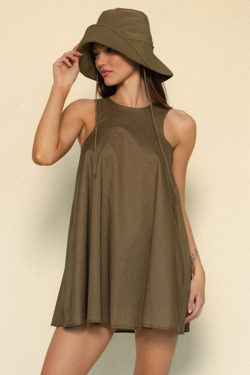 Khaki sleeveless A-line dress with crew neckline and relaxed fit, modeled with matching wide-brimmed hat.