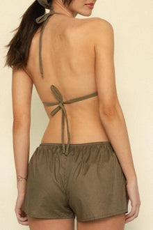 Khaki drawstring shorts with low rise and relaxed fit, shown from back view on model.