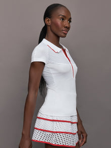 Model wears a mesh short sleeved lightweight tennis polo with red detailing.
