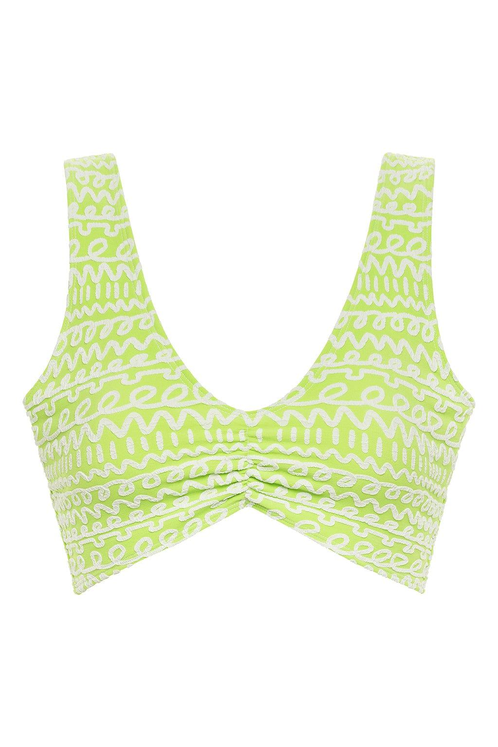 Lime green and white patterned crop top with geometric print and twisted front detail.