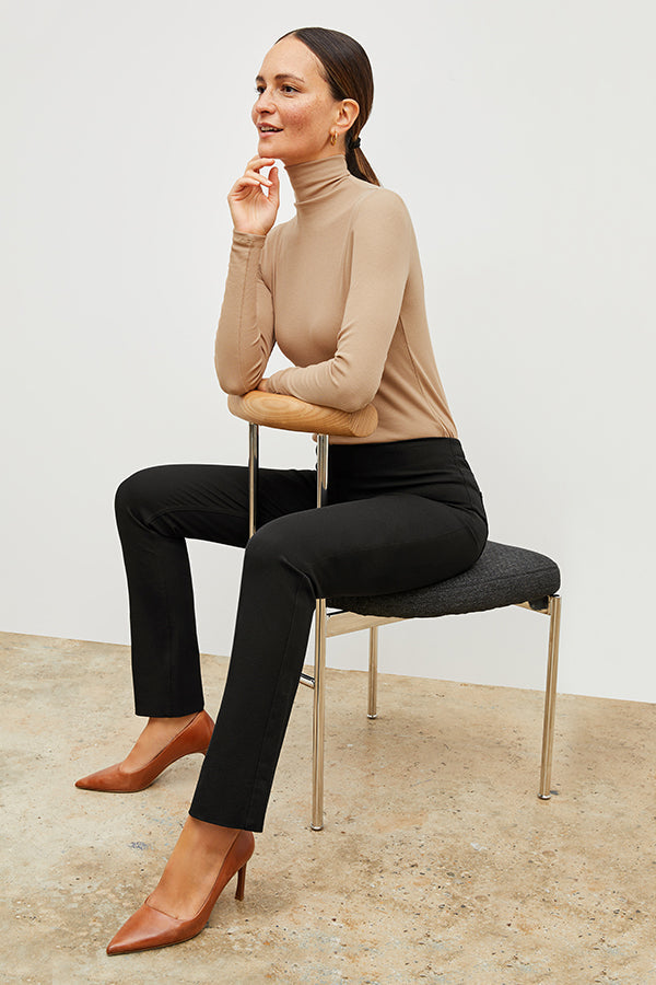 Front image of a woman standing wearing the axam top in camel | Exclude | Grid Hover