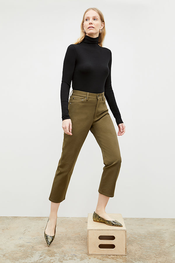 Front image of a woman standing wearing the axam top in black | Exclude