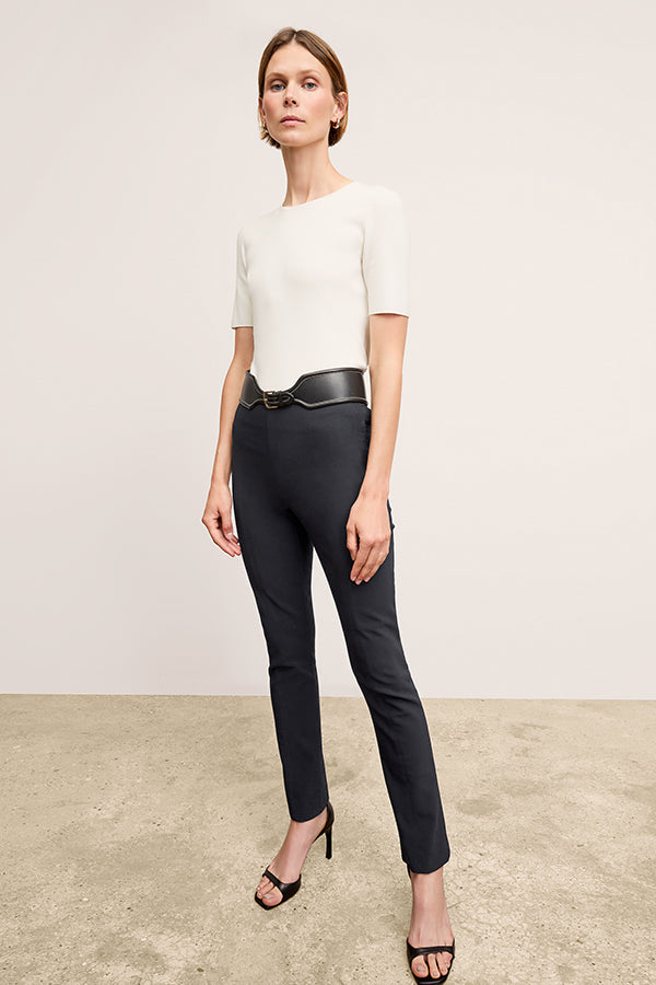 Front image of a woman standing wearing the Foster Pant—Everstretch in Black | Exclude