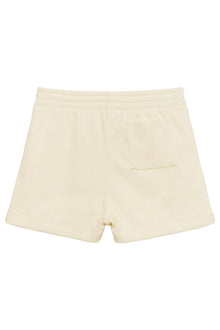 Cream ribbed swim trunks with elastic waistband, back pocket, and drawstring closure.
