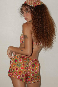 Low-rise drawstring shorts in tan silk with multicolored floral print and matching bandeau top.