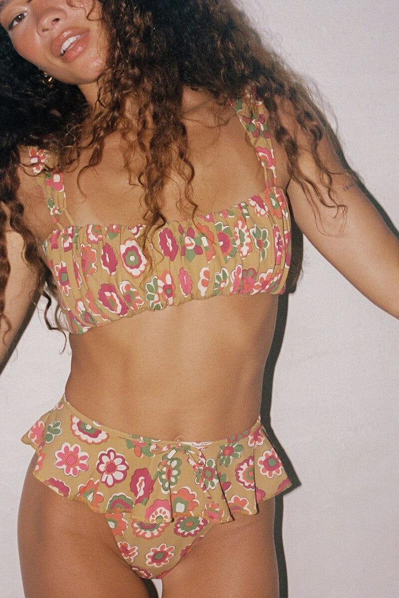 Tan bikini top with red, pink, and green floral print, square neckline, and adjustable straps.